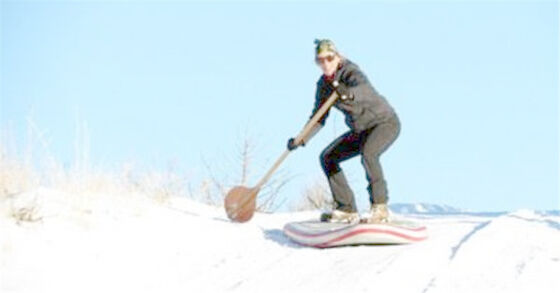 Κρύα χειμερινή στάση της EVA επάνω στο κουπί που επιβιβάζεται στο διογκώσιμο πίνακα σκι χιονιού